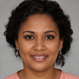 Joyful black adult female with medium  brown hair and brown eyes