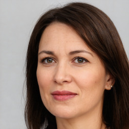 Joyful white adult female with long  brown hair and brown eyes