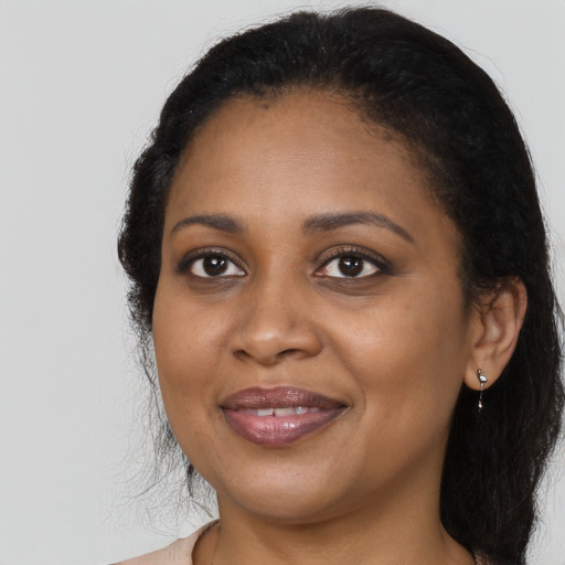 Joyful black adult female with long  black hair and brown eyes