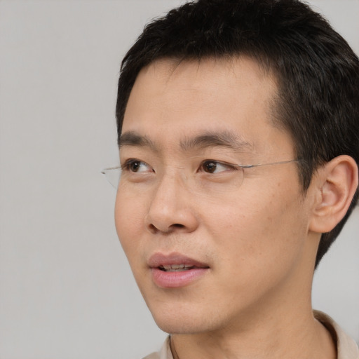 Joyful asian young-adult male with short  black hair and brown eyes