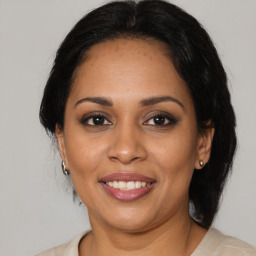 Joyful black adult female with medium  brown hair and brown eyes