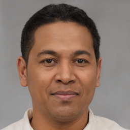 Joyful latino adult male with short  brown hair and brown eyes
