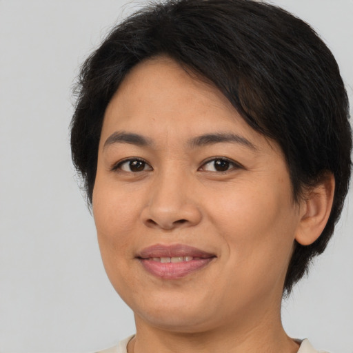 Joyful asian adult female with short  brown hair and brown eyes