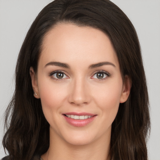 Joyful white young-adult female with long  brown hair and brown eyes