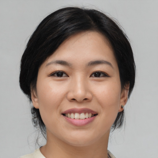 Joyful asian young-adult female with medium  black hair and brown eyes
