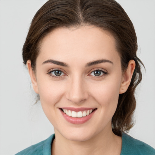 Joyful white young-adult female with medium  brown hair and green eyes