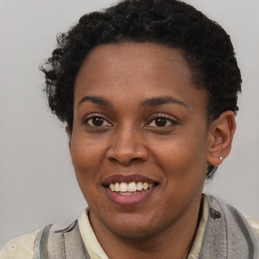 Joyful black young-adult female with short  brown hair and brown eyes