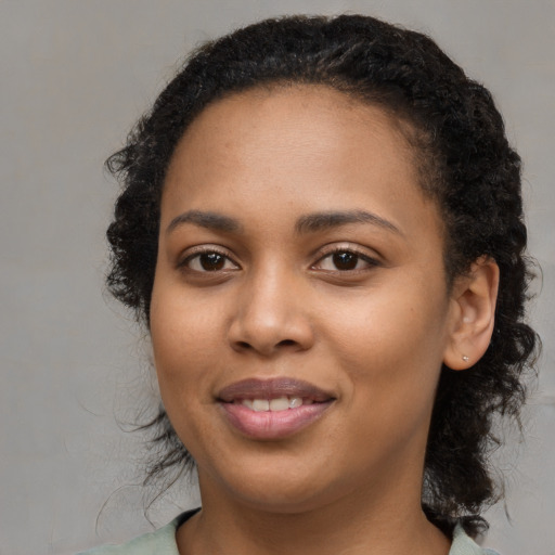 Joyful black young-adult female with medium  black hair and brown eyes