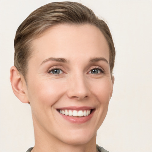 Joyful white young-adult female with short  brown hair and grey eyes