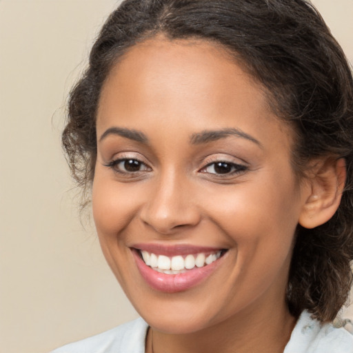 Joyful latino young-adult female with medium  brown hair and brown eyes