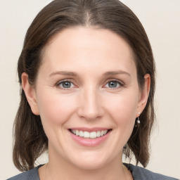 Joyful white young-adult female with medium  brown hair and grey eyes