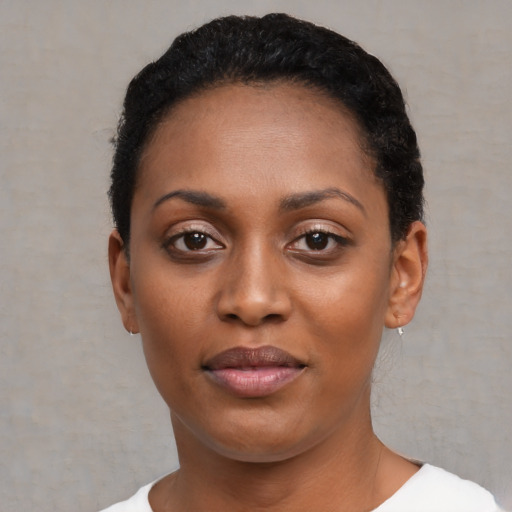 Joyful black young-adult female with short  black hair and brown eyes