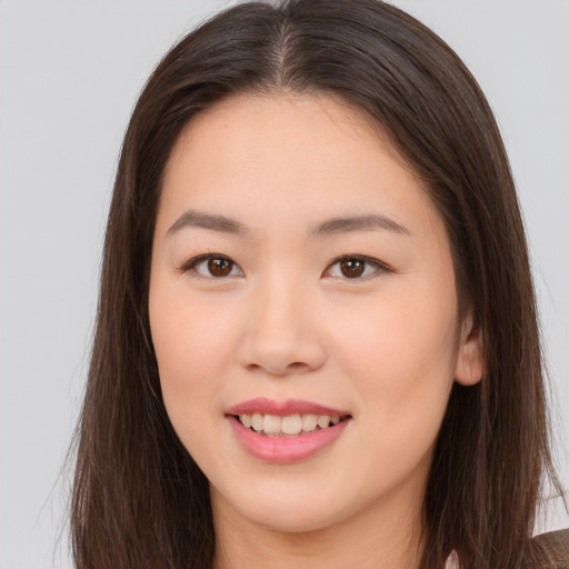 Joyful asian young-adult female with long  brown hair and brown eyes