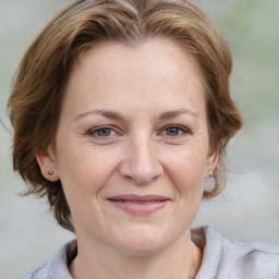 Joyful white adult female with medium  brown hair and blue eyes