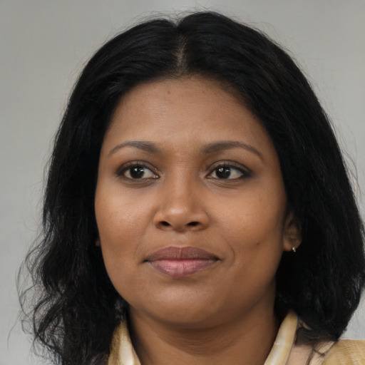 Joyful black young-adult female with long  brown hair and brown eyes