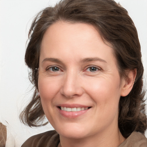 Joyful white adult female with medium  brown hair and grey eyes