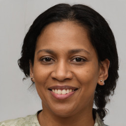 Joyful latino adult female with medium  brown hair and brown eyes