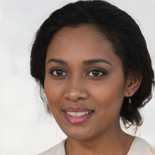 Joyful black young-adult female with medium  black hair and brown eyes