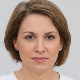 Joyful white adult female with medium  brown hair and green eyes