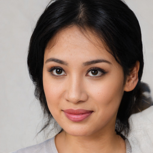 Joyful latino young-adult female with medium  black hair and brown eyes