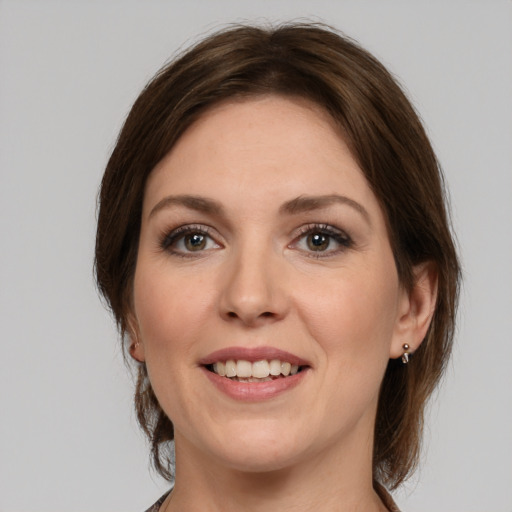 Joyful white young-adult female with medium  brown hair and grey eyes