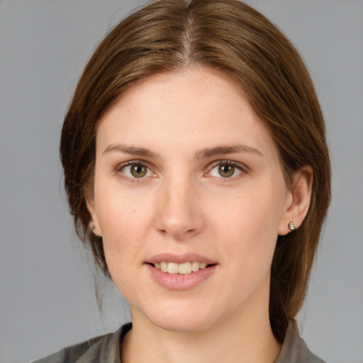 Joyful white young-adult female with medium  brown hair and grey eyes