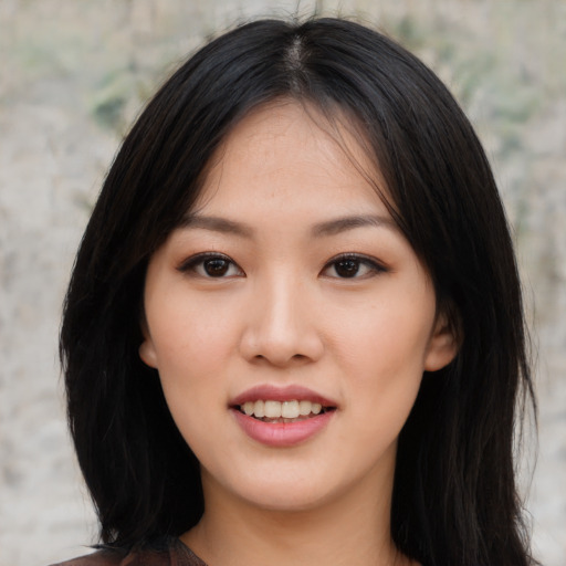 Joyful asian young-adult female with long  black hair and brown eyes