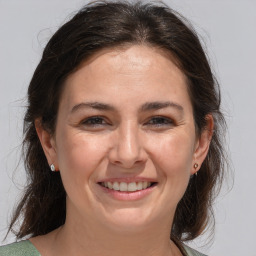 Joyful white adult female with medium  brown hair and brown eyes