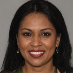 Joyful black young-adult female with long  brown hair and brown eyes