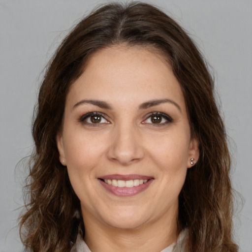 Joyful white young-adult female with long  brown hair and brown eyes