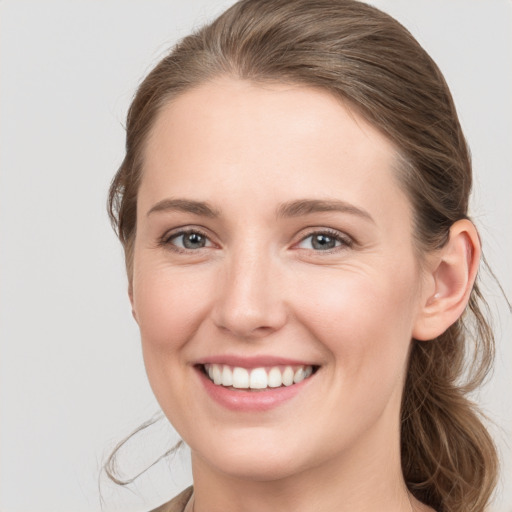 Joyful white young-adult female with medium  brown hair and grey eyes