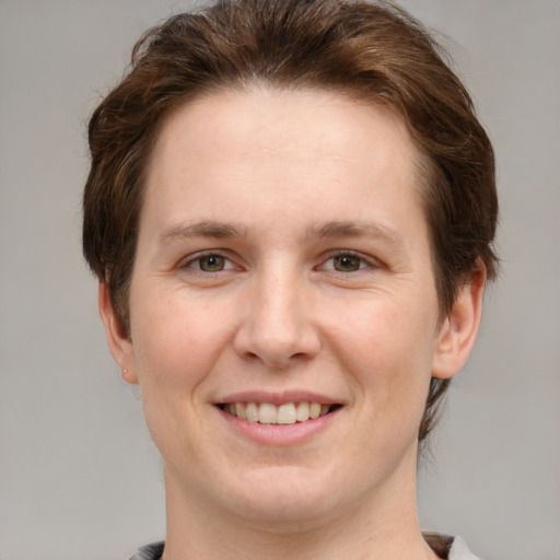 Joyful white young-adult female with medium  brown hair and grey eyes