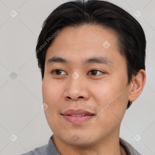 Joyful asian young-adult male with short  brown hair and brown eyes