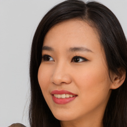 Joyful asian young-adult female with long  brown hair and brown eyes