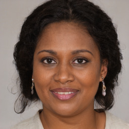 Joyful black adult female with medium  brown hair and brown eyes