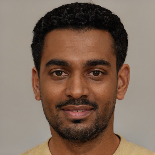 Joyful black young-adult male with short  black hair and brown eyes