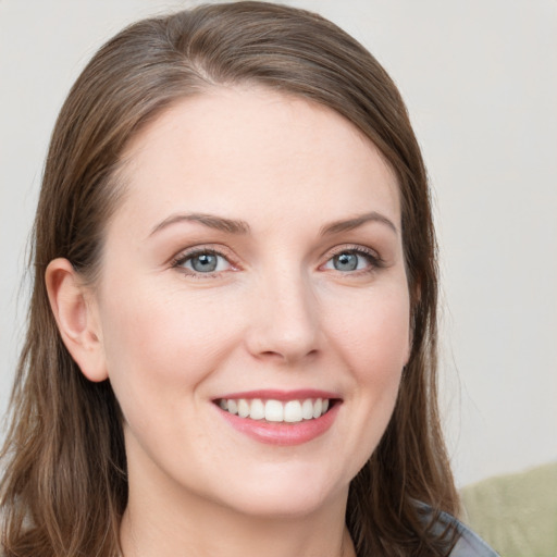 Joyful white young-adult female with long  brown hair and grey eyes