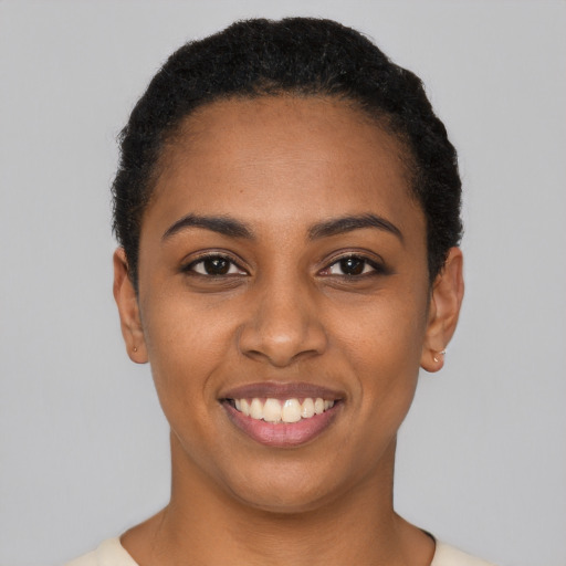 Joyful black young-adult female with short  black hair and brown eyes