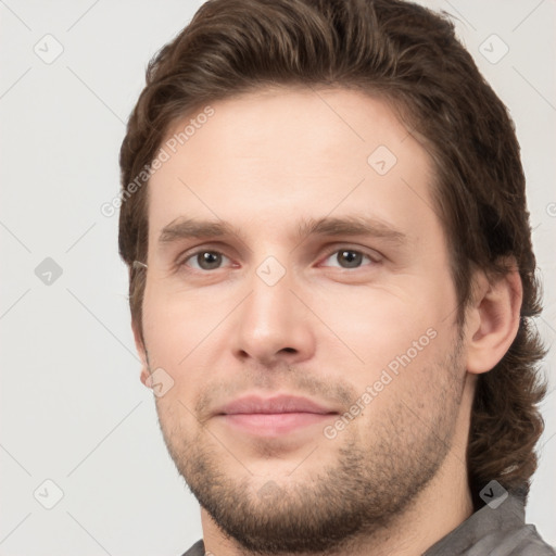 Joyful white young-adult male with short  brown hair and grey eyes