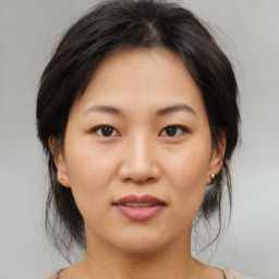 Joyful asian young-adult female with medium  brown hair and brown eyes