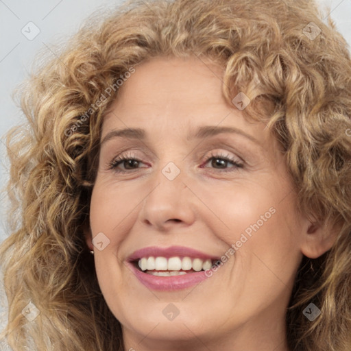 Joyful white adult female with long  brown hair and brown eyes