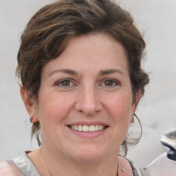 Joyful white adult female with medium  brown hair and grey eyes