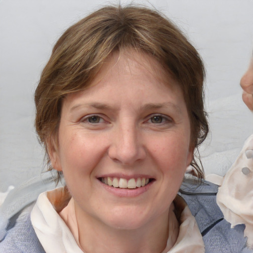 Joyful white young-adult female with medium  brown hair and blue eyes