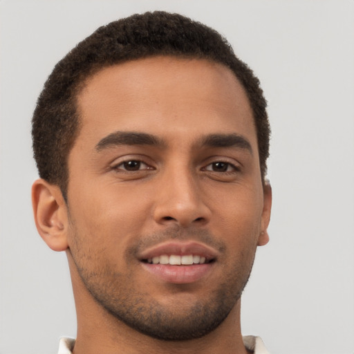 Joyful latino young-adult male with short  brown hair and brown eyes