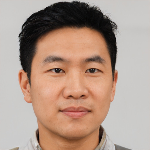 Joyful asian young-adult male with short  black hair and brown eyes