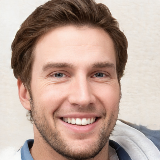 Joyful white young-adult male with short  brown hair and grey eyes