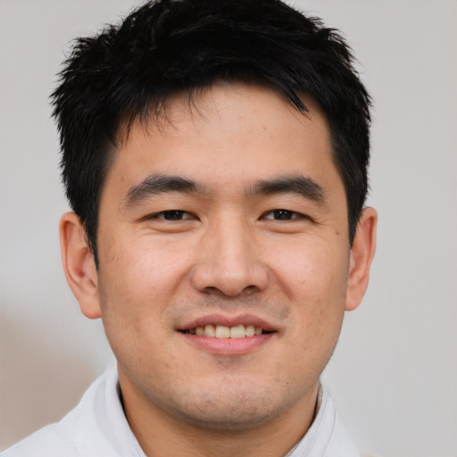 Joyful asian young-adult male with short  brown hair and brown eyes