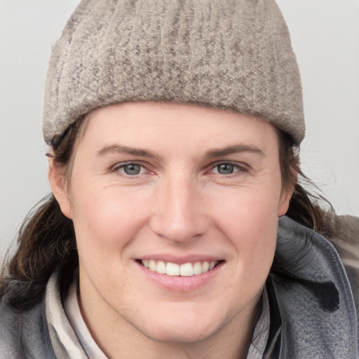 Joyful white young-adult female with short  brown hair and blue eyes