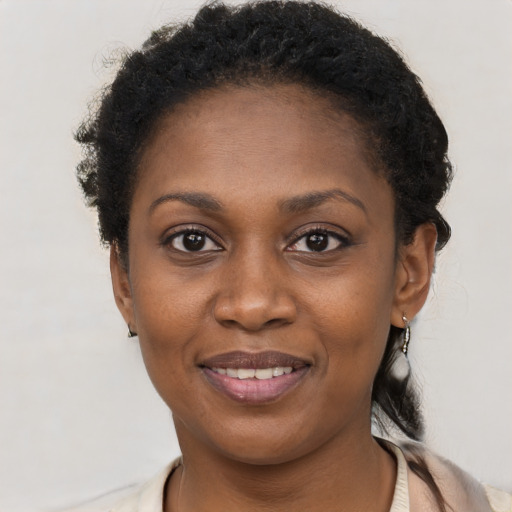 Joyful black young-adult female with short  brown hair and brown eyes