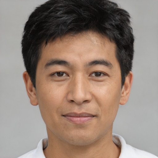 Joyful asian young-adult male with short  black hair and brown eyes